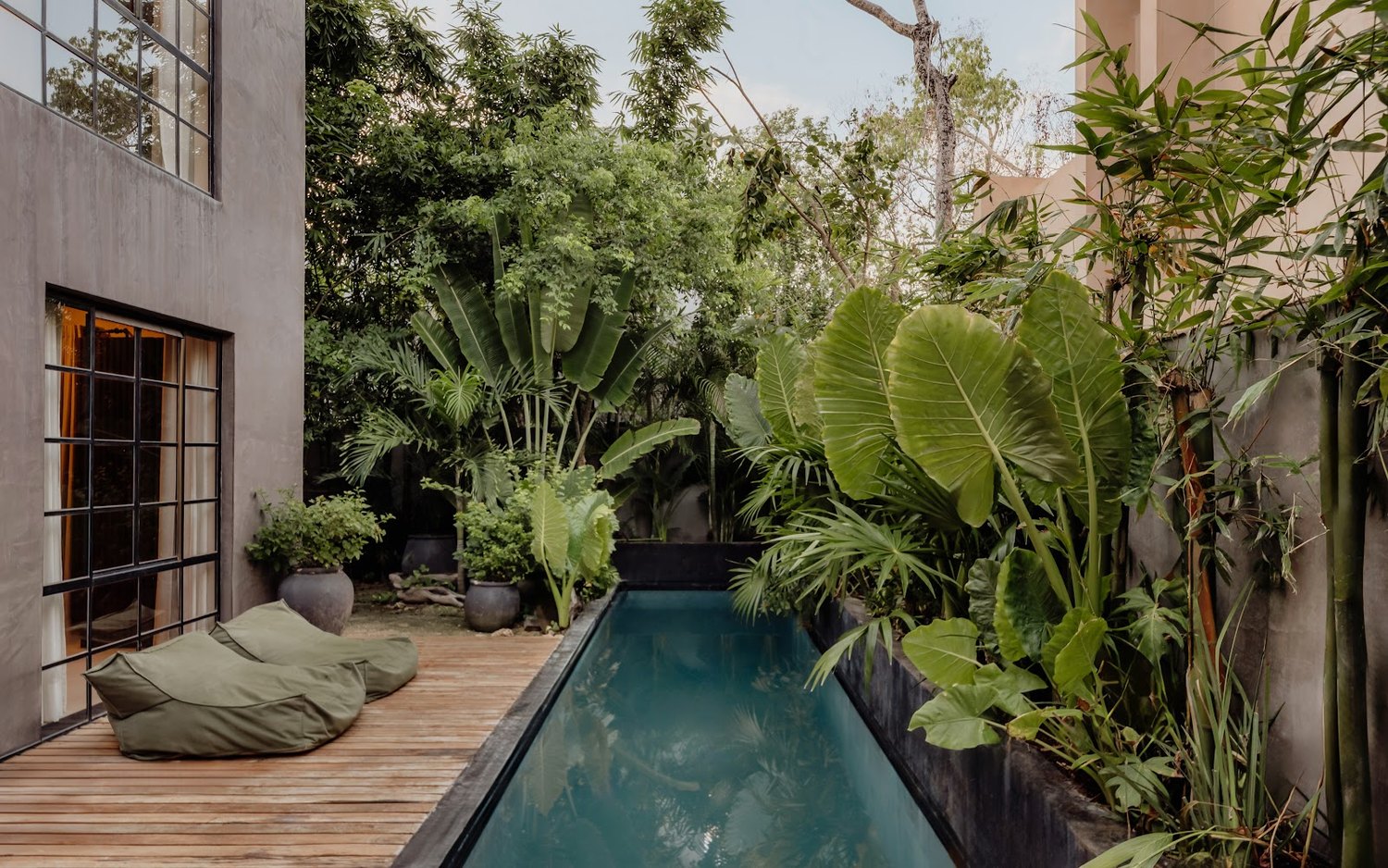 The lower pool, wrapped in garden &mdash; the quiet counterpoint to the rooftop plunge pool.